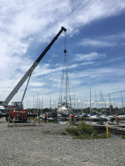 A photo of a boat being lifted by a large machine. A boat survey ontario.